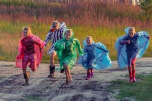 people in green and blue jacket walking on dirt road during daytime